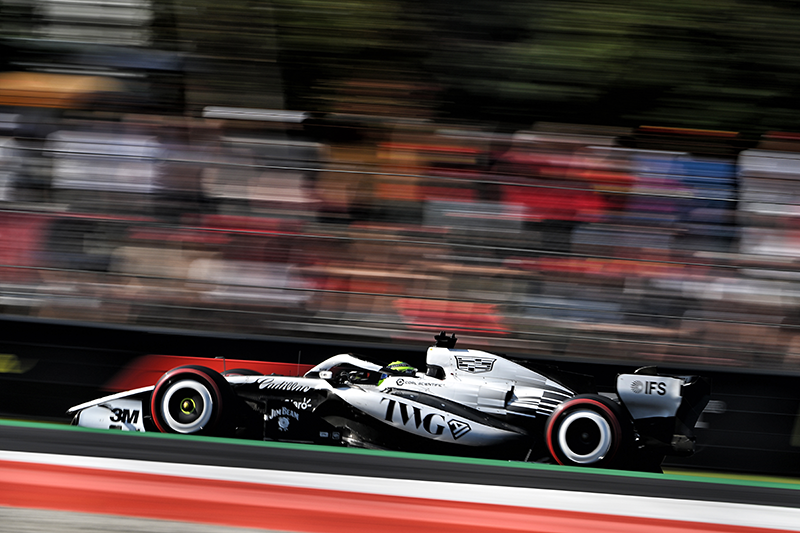 "Monoplace F1 Cadillac blanche et noire en pleine accélération sur le circuit de Monza avec flou de vitesse F1 Cadillac